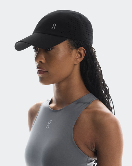 Woman wearing a black cap and gray tank top on a white background - On Lightweight Cap - Black