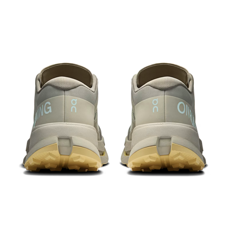 A pair of light gray and beige trail running shoes shown from the back, featuring light blue 'ON' branding and a gum-colored outsole, on a solid white background. - On Cloudultra 3 Shoes (Men's) - Brume/Winter