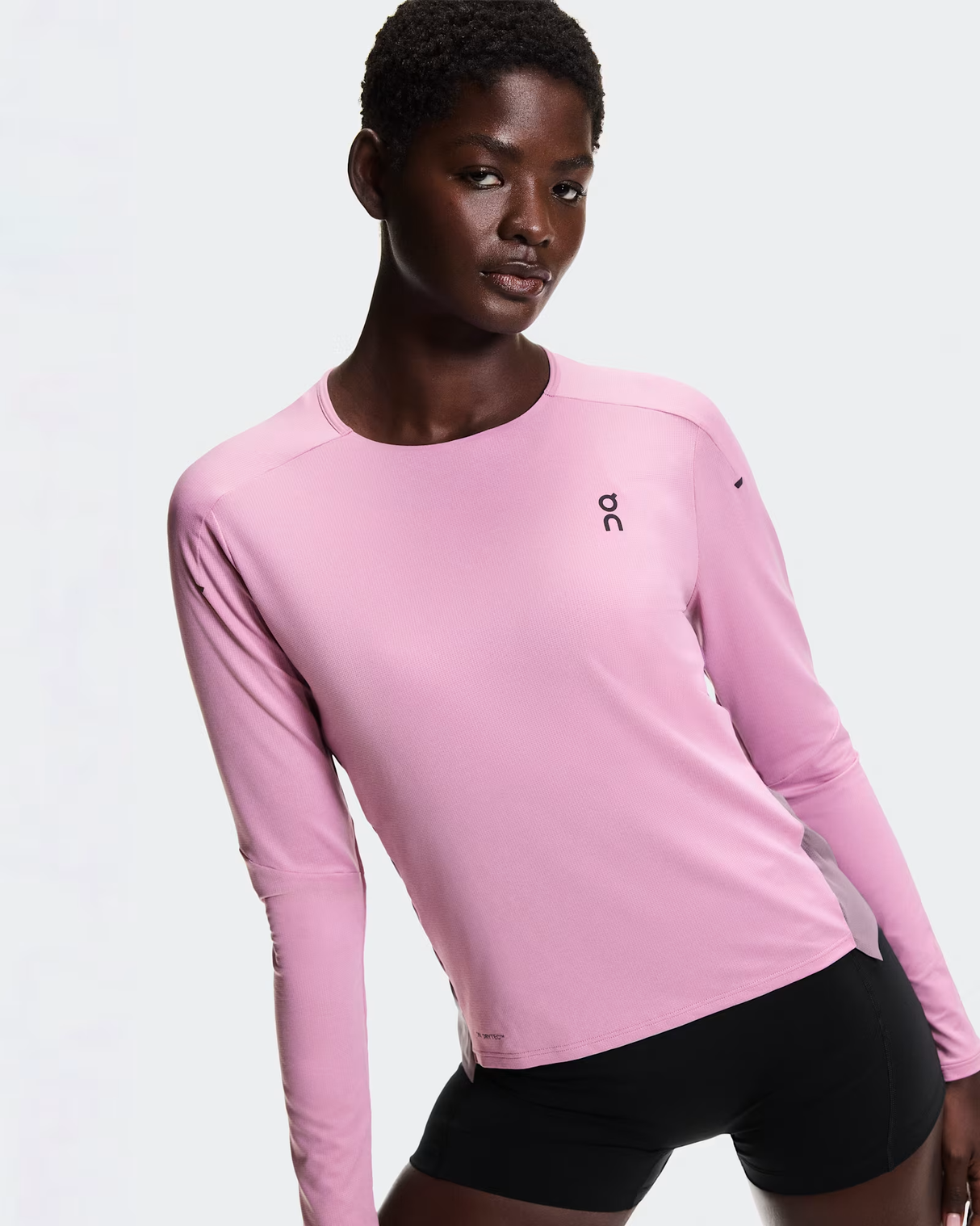 Person wearing a pink long-sleeve athletic shirt with a logo on a light gray background - On Performance Long-T (Women's) - Dewberry/Sakura