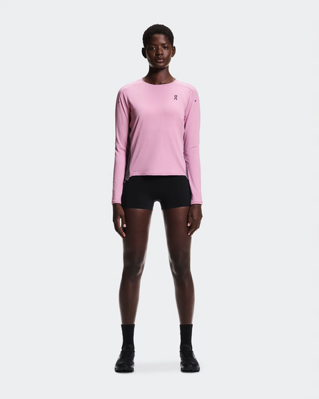Person wearing a pink long-sleeve athletic shirt and black shorts on a white background - On Performance Long-T (Women's) - Dewberry/Sakura