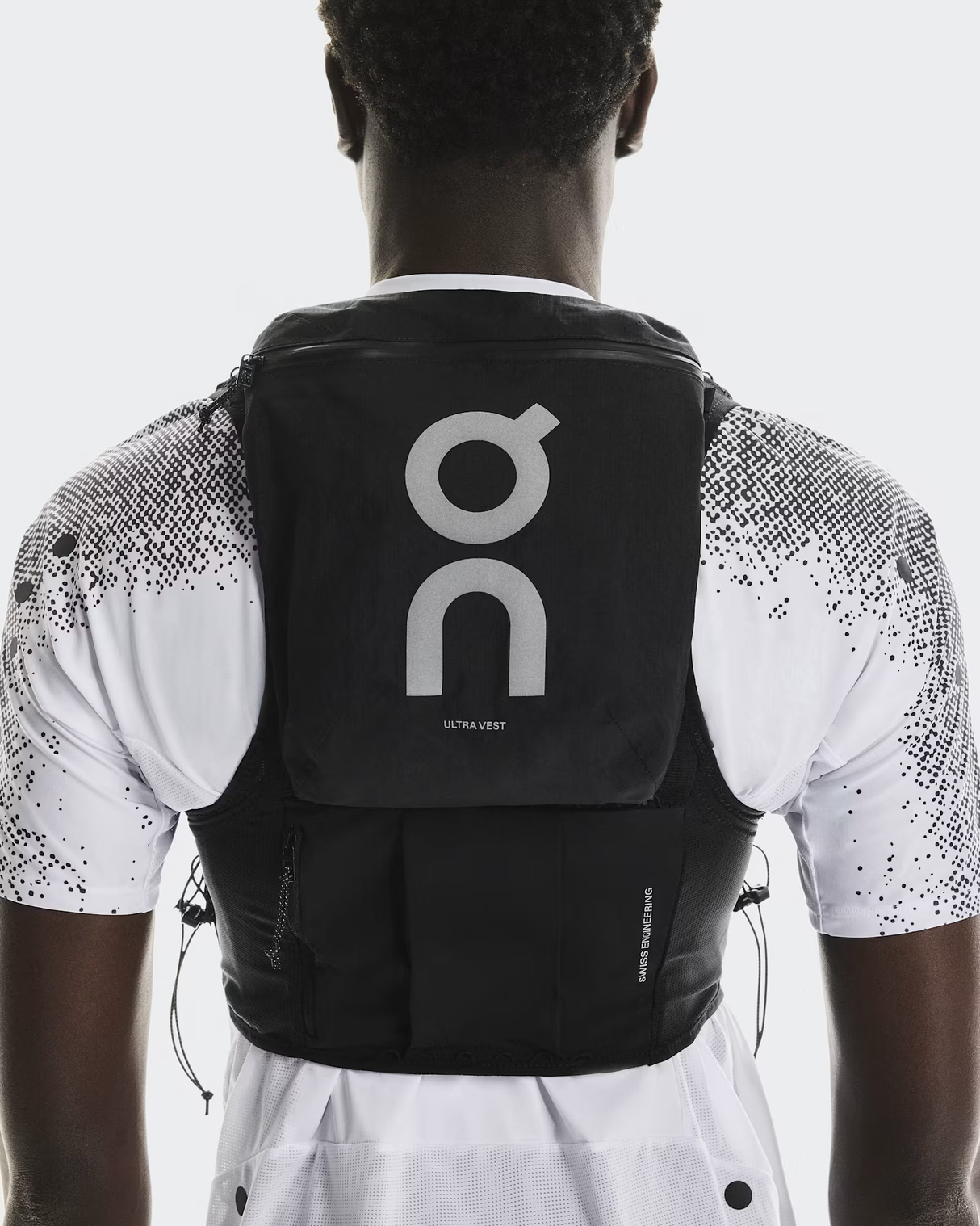 Person wearing a black hydration pack with a visible brand logo on a white background - On Ultra Vest Pro (Unisex) - Black