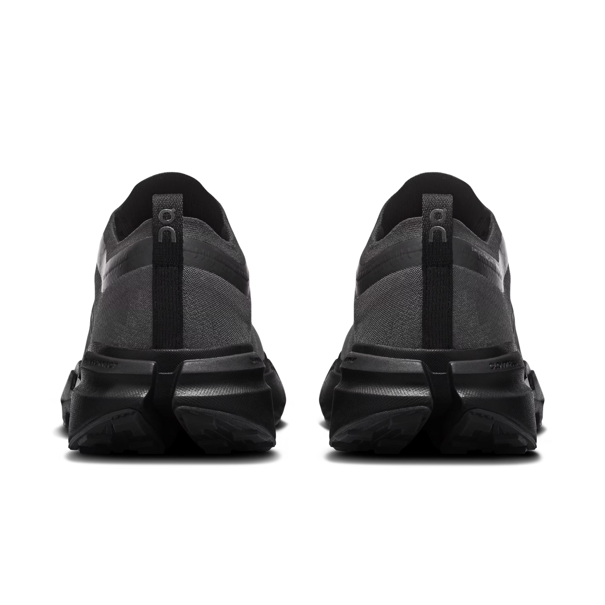 A pair of black and dark gray athletic sneakers shown from the rear, featuring chunky black midsoles and heel pull tabs with the 'On' logo, on a plain white background. - On Cloudsoma Shoes (Women's) - Black/black