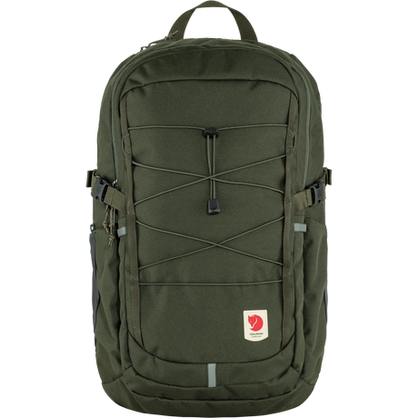 A Fjällev backpack in olive green, featuring a front zippered pocket with crisscross compression straps, side pockets, and the signature Fjällev logo patch on the lower front, set against a plain white background. - Fjällräven Skule 28 Backpack - Deep Forest