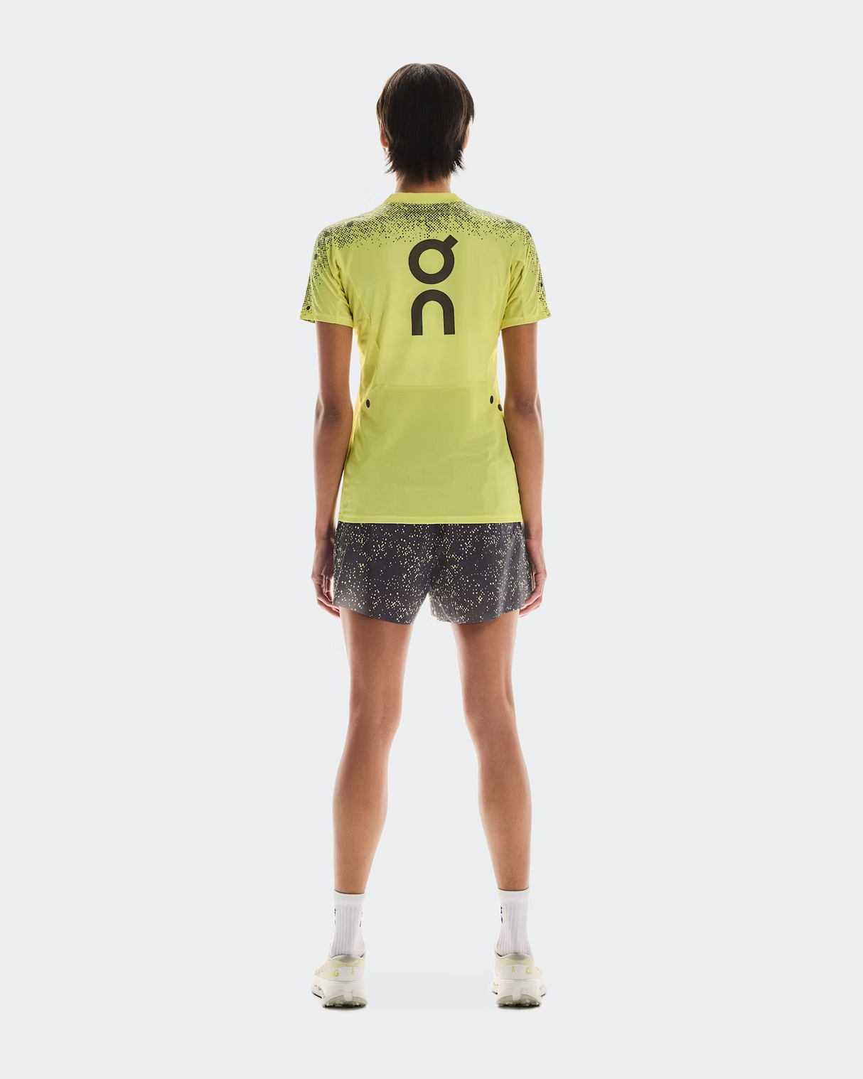 Person wearing a bright green sports outfit with 'On' branding on a white background - On Ultra Shorts (Women's) - Iron/Lime