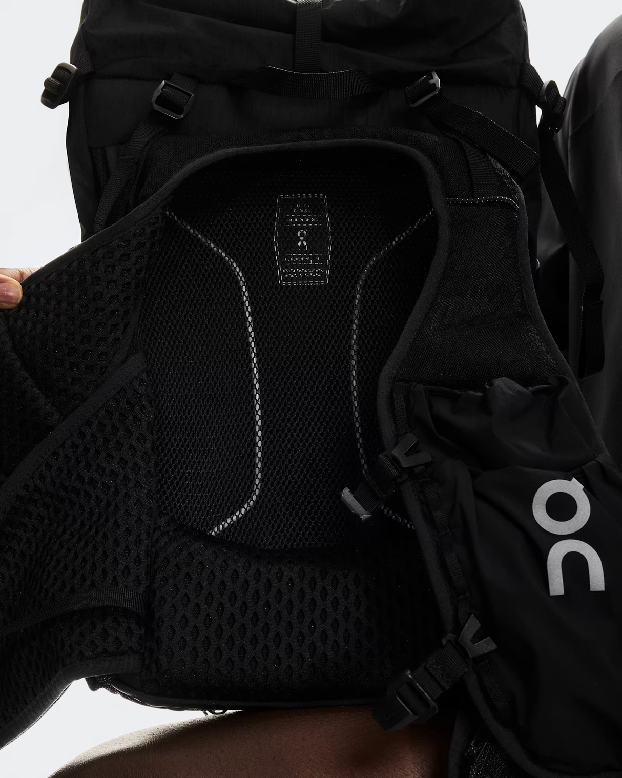 Close-up of a black backpack with a visible brand logo on a light gray background - On Trail Pack 20L - Black