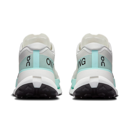 A pair of On running shoes shown from the rear, featuring a white and light mint green upper with black and white soles, set against a plain white background. - On Cloudultra Pro Shoes (Men's) - Ivory/Celeste