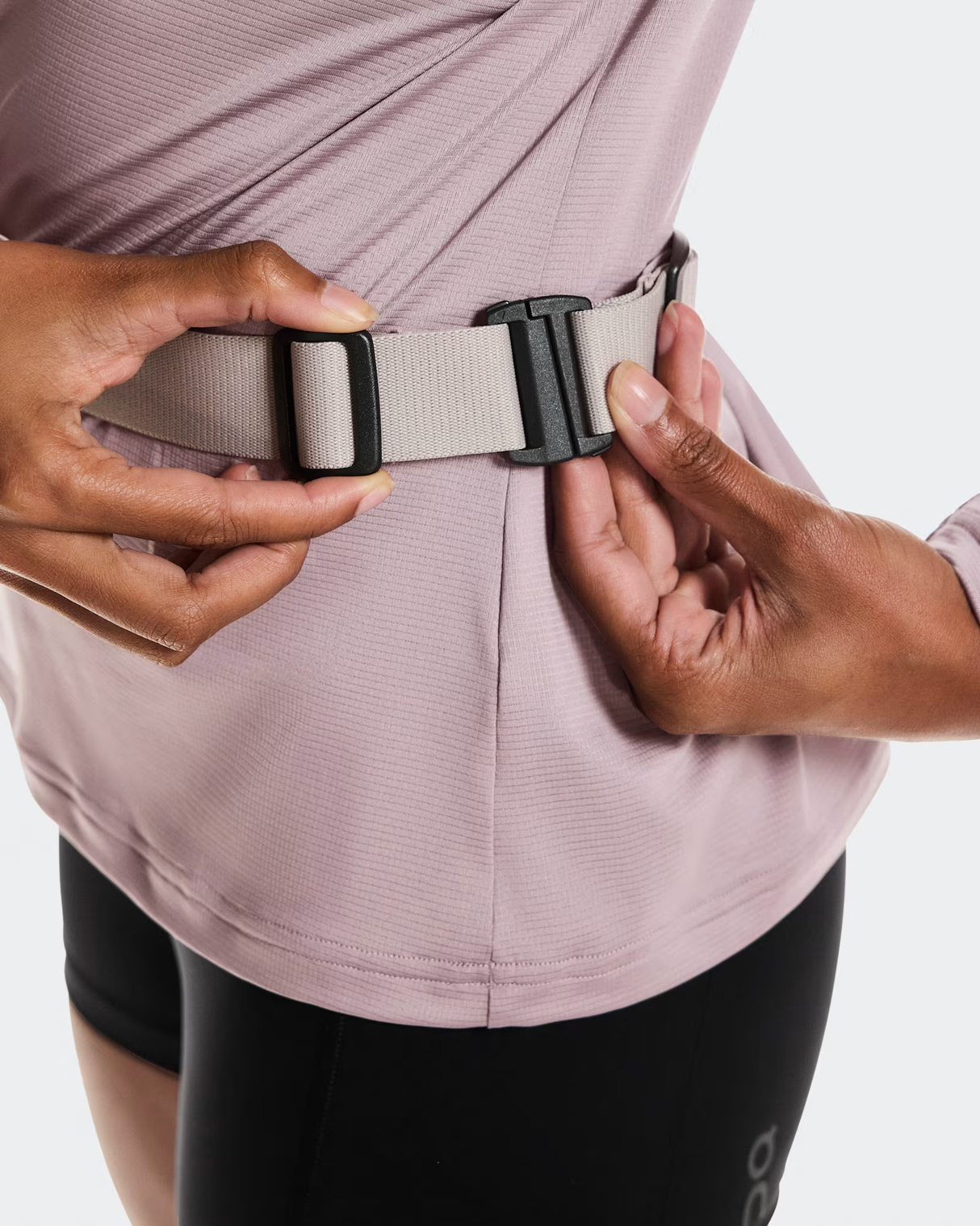 Person adjusting a belt with a neutral color on a plain background - On Speed Belt (Unisex) - Fog