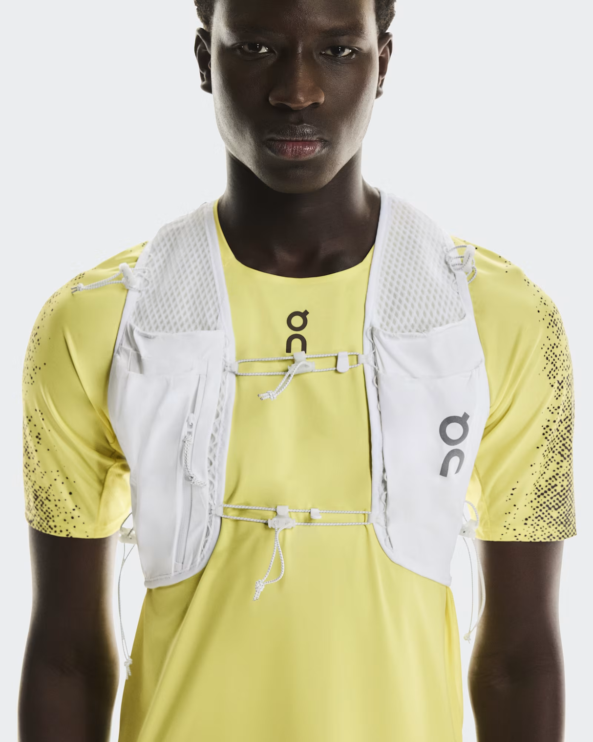 Person wearing a yellow athletic outfit with a white vest on a light gray background - On Ultra Vest Pro (Unisex) - White