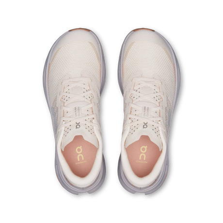 A top-down view of a pair of On Cloudrunning sneakers in a light cream and beige colorway, featuring a breathable mesh upper, white laces, and a soft pinkish-orange footbed visible inside the open toes. - On Cloudultra 3 Shoes (Women's) - Oyster/Ether