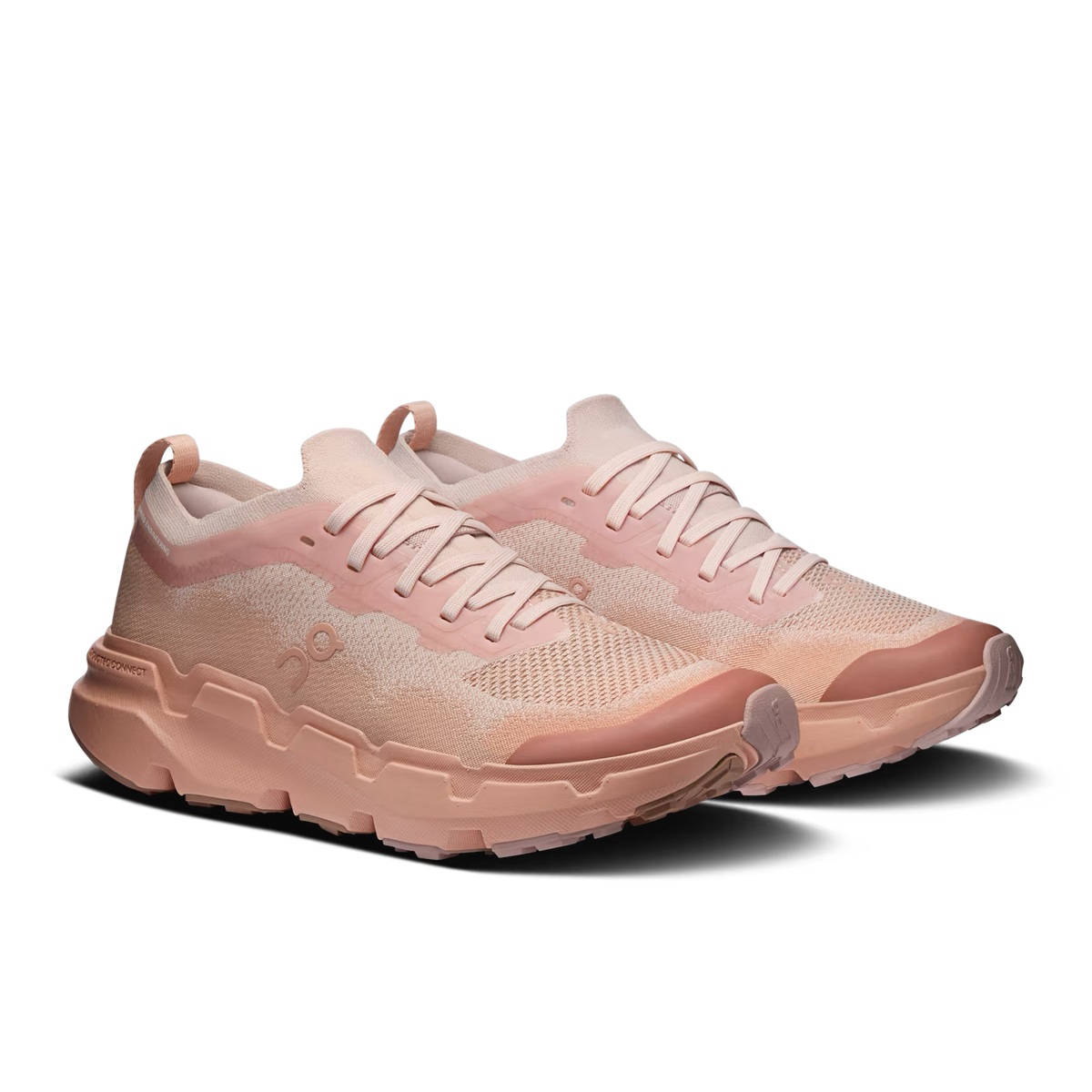 A pair of light pink and peach sneakers with a chunky, sculpted sole, shown against a solid black background. - On Cloudsoma Shoes (Women's) - Doe/Argil