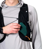 Person wearing a black backpack with a green pouch, holding a phone. - Hyperlite Mountain Gear Pemi 15 Backpack