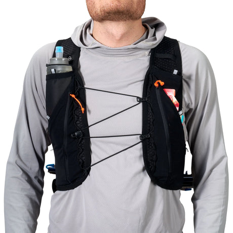 Person wearing a black hydration vest with multiple pouches on a white background - Hyperlite Mountain Gear Pemi 15 Backpack