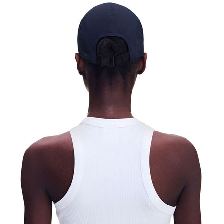 A person shown from the back wearing a dark navy baseball cap and a white ribbed tank top against a plain white background. - On Lightweight Cap - Navy