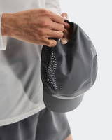 Person holding a gray cap with a textured surface on a light gray background - On Lightweight Cap - Rock