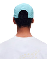 Back view of a person wearing a light blue baseball cap with a black adjustable strap, shown against a plain white background. - On Lightweight Cap - Wash